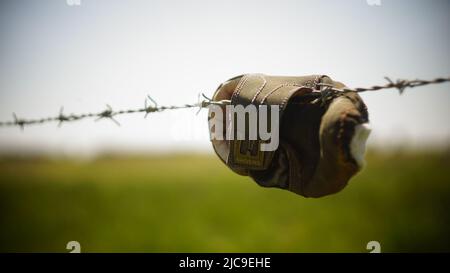 Schuh hängen an Stacheldraht Stockfoto