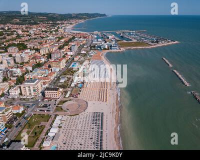 Italien, Juni 2022; Luftaufnahme von Fano mit Meer, Stränden, Hafen, Sonnenschirmen Stockfoto