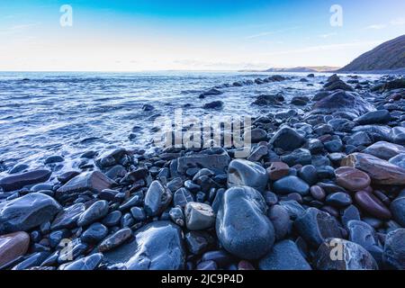 Farbenfrohe Wet Rocks am Bucks Mills Beach in High Tide mit Blick auf den Strand und die Küste von North Devon, Bucks Mills, Devon, Großbritannien. Stockfoto