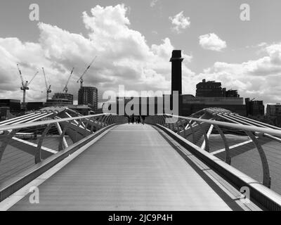 London, Großraum London, England, Juni 08 2022: Monochrom. Millennium Bridge mit Tate Modern Gebäude im Hintergrund. Stockfoto