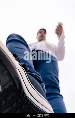 Junger Mann, der eine Leiter hinabsteigt. Blick auf Contrapicado. Stockfoto