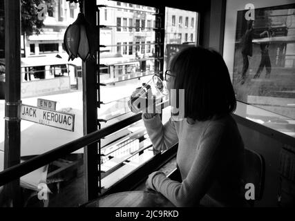 Eine Frau genießt ein Pint Bier im Vesuvio Cafe, einer bekannten Bar in San Francisco, Kalifornien, die von Mitgliedern der Beat Generation 1950s besucht wird. Stockfoto