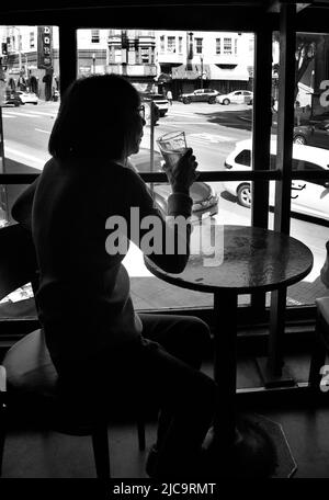 Eine Frau genießt ein Pint Bier im Vesuvio Cafe, einer bekannten Bar in San Francisco, Kalifornien, die von Mitgliedern der Beat Generation 1950s besucht wird. Stockfoto