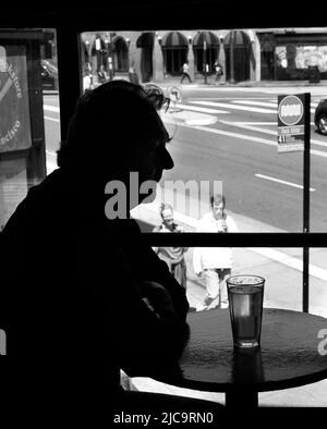 Ein Mann genießt ein Pint Bier im Vesuvio Cafe, einer bekannten Bar in San Francisco, Kalifornien, die von Mitgliedern der Beat Generation 1950s besucht wird. Stockfoto