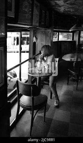 Eine Frau genießt ein Pint Bier im Vesuvio Cafe, einer bekannten Bar in San Francisco, Kalifornien, die von Mitgliedern der Beat Generation 1950s besucht wird. Stockfoto