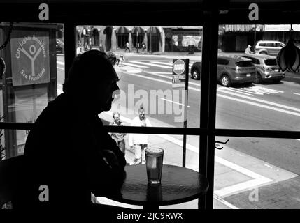 Ein Mann genießt ein Pint Bier im Vesuvio Cafe, einer bekannten Bar in San Francisco, Kalifornien, die von Mitgliedern der Beat Generation 1950s besucht wird. Stockfoto