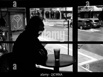 Ein Mann genießt ein Pint Bier im Vesuvio Cafe, einer bekannten Bar in San Francisco, Kalifornien, die von Mitgliedern der Beat Generation 1950s besucht wird. Stockfoto