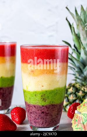 Farbenfroher, leyerierter Frucht-Smoothie mit Regenbogen Stockfoto
