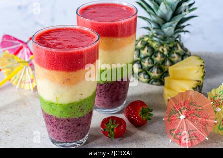Farbenfroher, leyerierter Frucht-Smoothie mit Regenbogen Stockfoto