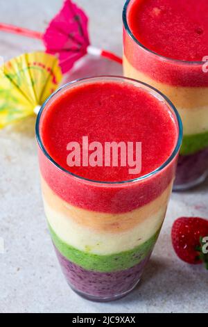 Farbenfroher, leyerierter Frucht-Smoothie mit Regenbogen Stockfoto