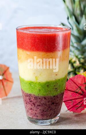 Farbenfroher, leyerierter Frucht-Smoothie mit Regenbogen Stockfoto