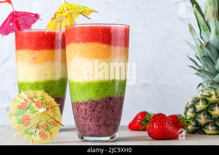 Farbenfroher, leyerierter Frucht-Smoothie mit Regenbogen Stockfoto