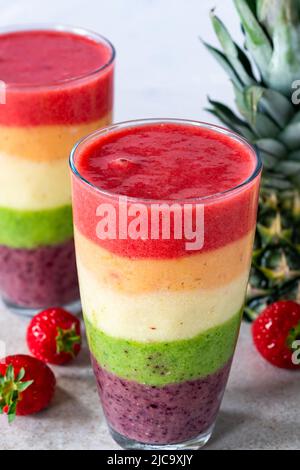 Farbenfroher, leyerierter Frucht-Smoothie mit Regenbogen Stockfoto