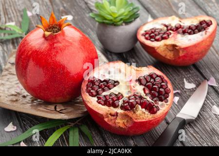 Granatapfel in Scheiben auf Holzhintergrund Stockfoto