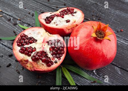 Granatapfel in Scheiben auf Holzhintergrund Stockfoto