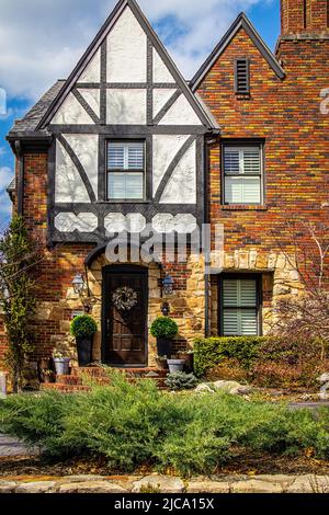 Nahaufnahme eines wunderschönen Eingangsweges aus Vintage-Backstein- und Steinhaus mit einem Fachwerk-Tudor-Giebel mit wunderschöner Landschaft und Türkranz Stockfoto