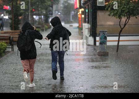 Ankara, Türkei. 11.. Juni 2022. Zwei Frauen werden vor dem Regen weglaufen gesehen. In Ankara, der Hauptstadt der Türkei, fallen heftige Regenfälle. (Bild: © Tunahan Turhan/SOPA Images via ZUMA Press Wire) Stockfoto