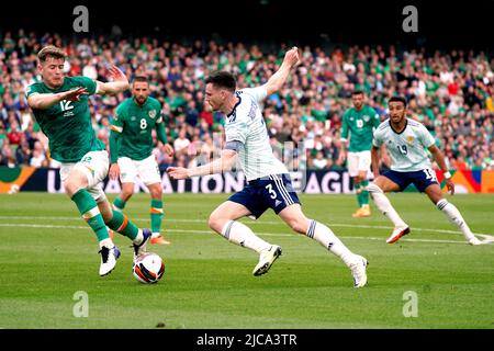 Der schottische Andy Robertson (Mitte) läuft beim Spiel der UEFA Nations League im Aviva Stadium, Dublin, gegen Nathan Collins (links). Bilddatum: Samstag, 11. Juni 2022. Stockfoto