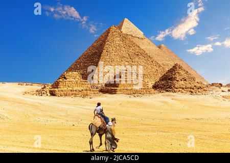 Der große Pyramidenkomplex und beduinen mit Touristen in der ägyptischen Wüste, Gizeh. Stockfoto