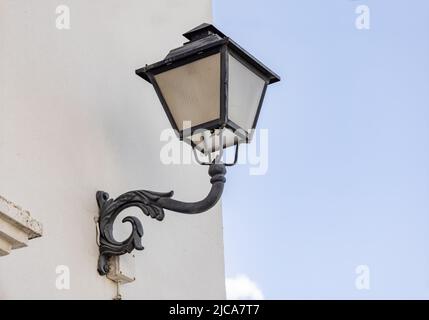 Eiserne Wandlampe in einer weiß getünchten Wand Stockfoto