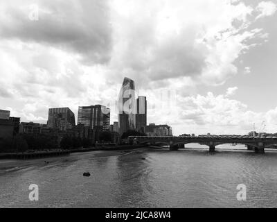 London, Großraum London, England, Juni 08 2022: Monochrom. Blackfriars Bridge, Hochhäuser und ein Strand Stockfoto