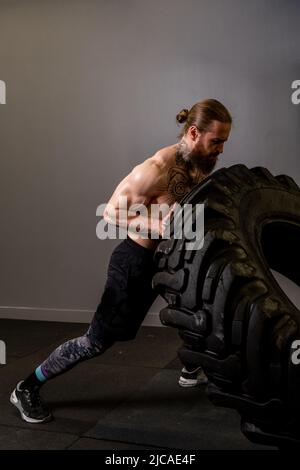 Fitness-Training Reifen Mann Rad kippen fit Lifestyle jung gesund, von Engagement Gewicht in schwer von Krafttraining, Kommissionierung Kreuz. Aktiv Stockfoto