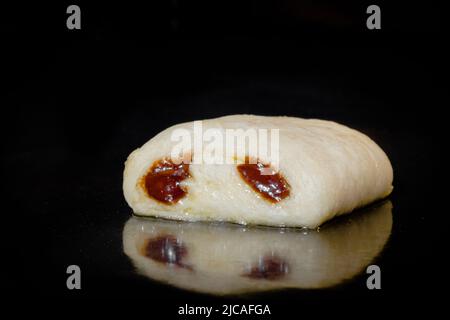 Ein ungekochter, hausgemachter Mini-Brötchen mit Schokoladenfüllung im Elektroofen Stockfoto