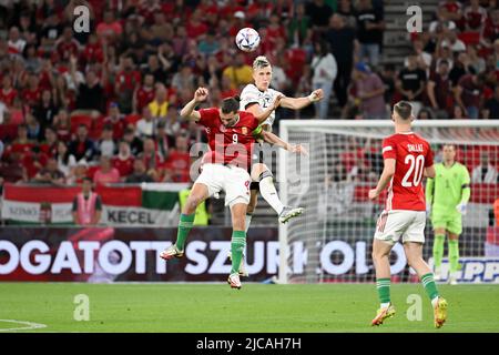 Budapest, Ungarn. 11.. Juni 2022. Fußball: Nations League A, Ungarn - Deutschland, Gruppenphase, Gruppe 3, Matchday 3, Puskás Aréna. Der ungarische Adam Szalai (M) und der deutsche Nico Schlotterbeck in Aktion. Quelle: Federico Gambarini/dpa/Alamy Live News Stockfoto