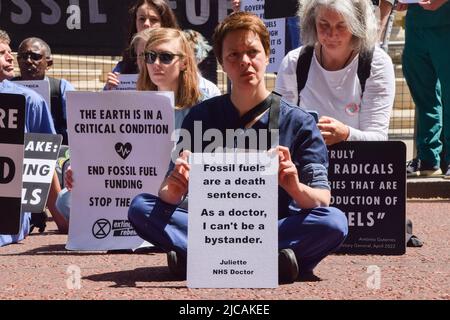 London, Großbritannien. 11.. Juni 2022. Ein Protestler hält während der Demonstration vor dem Finanzministerium ein Plakat mit antifossilen Brennstoffen. Ärzte, Krankenschwestern und andere Gesundheitsfachkräfte des Extinction Rebellion versammelten sich in Westminster zu einem Protest, um ein Ende der Investitionen in fossile Brennstoffe zu fordern. Kredit: SOPA Images Limited/Alamy Live Nachrichten Stockfoto