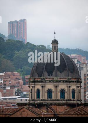 Blick auf die Kathedrale und die Gebäude in der Stadt Medellin, umgeben von grünen Bergen an einem bewölkten Tag Stockfoto
