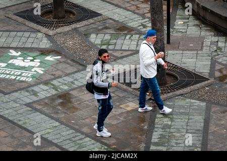 Medellin, Antioquia, Kolumbien - März 6 2022: Kolumbianische Jugendliche, die auf der Straße einen Kaffee zu sich nehmen, gehen auf dem Platz neben der U-Bahn-Station Stockfoto