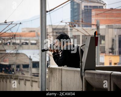 Medellin, Antioquia, Kolumbien - März 6 2022: Kolumbianische Frau mit schwarzem Haar trägt eine schwarze Maske, große Ohrringe und eine Brille macht mit ihrer Cam Bilder Stockfoto