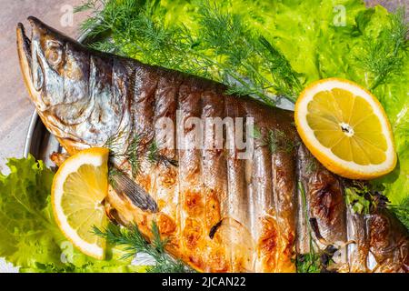 Gegrillter roter Fisch rosa Lachs mit Kräutern und Zitrone. Kochen gesunde leckere Speisen im Freien. Stockfoto