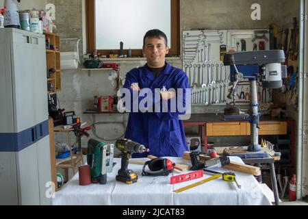 Bild eines Handwerkers in seiner Werkstatt mit einem Tisch vor Arbeitsgeräten. DIY-Arbeitsbeispiel und Verweis auf ich kann es beheben Stockfoto