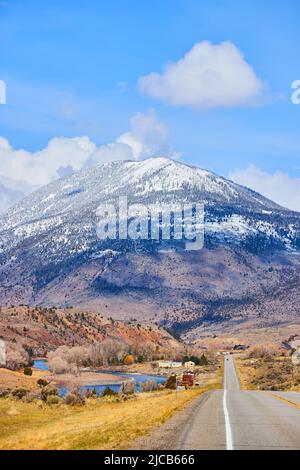 Atemberaubende schneebedeckte Berge von der Straße, die im Frühjahr zu ihnen führt Stockfoto