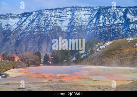 Die atemberaubende heiße Quelle blickt auf verschneite Berge in Yellowstone Stockfoto