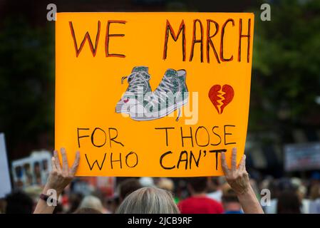 March for Our Lives 2022, Boston, MA, USA: Tausende versammelten sich am Boston Waterfront, als über 450 Demonstrationen gegen Waffengewalt in den USA stattfanden. Demonstrator hält ein Schild mit einem Paar grüner Converse Schuhe mit einem Herz auf einer Zehe, Das gleiche, wie die 10-jährige Maite Rodriguez trug, als sie eine von 19 Schülern war, die am 24. Mai 2022 an der Robb-Grundschule in Uvalde, TX, gedreht wurden. Kredit: Chuck Nacke / Alamy Live Nachrichten Stockfoto