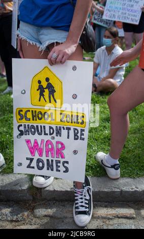 March for Our Lives 2022, Boston, MA, USA: Tausende versammelten sich am Ufer von Boston, als über 450 Demonstrationen gegen Waffengewalt in den USA stattfanden. Das Foto zeigt eine junge Frau, die Schuhe von Converse trägt und ein Schild mit eingeschnittenen Einschusslöchern in der Hand hält. Kredit: Chuck Nacke / Alamy Live Nachrichten Stockfoto