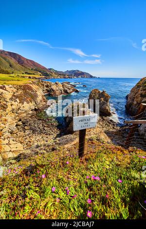 Privates No-Entry-Schild am Zaun neben dem atemberaubenden Ozean der Westküste mit felsigen Klippen Stockfoto