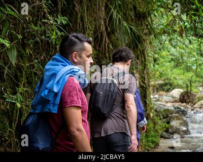 La Estrella, Antioquia, Kolumbien - Februar 13 2022: Zwei junge männliche Freunde wandern an einem Fluss mitten in der Natur Stockfoto