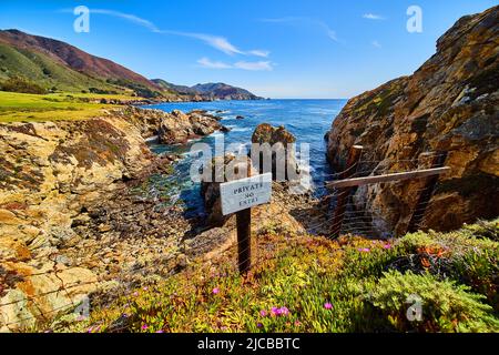 Privates Schild neben den Klippen der Westküste und dem Meer Stockfoto