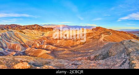 Berge mit Wellen von Sedimentfarben und Wanderweg durch die Gipfel im Death Valley Stockfoto