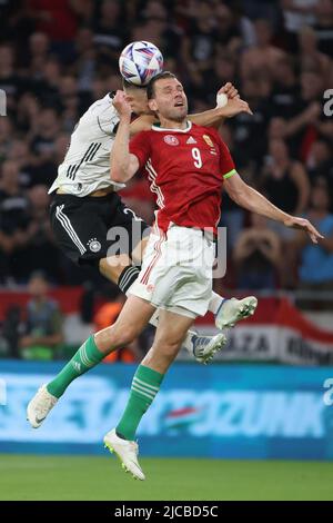 Budapest. 11.. Juni 2022. Der deutsche Nico Schlotterbeck (L) spielt mit dem ungarischen Adam Szalai während der UEFA Nations League Ein Fußballspiel zwischen Ungarn und Deutschland am 11. Juni 2022 im Stadion der Puskas Arena in Budapest, Ungarn. Quelle: Attila Volgyi/Xinhua/Alamy Live News Stockfoto