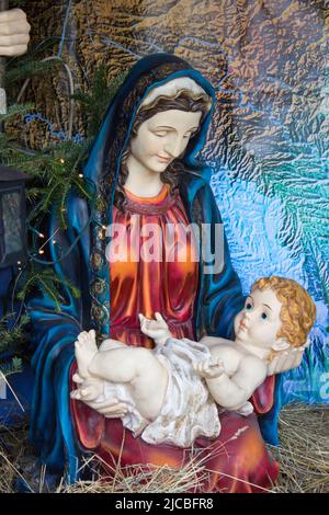 Maria gebar Jesus und hält sie auf den Armen und blickt auf ihn Stockfoto