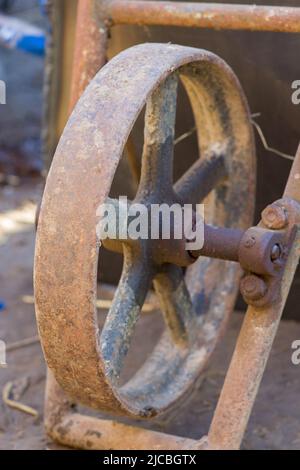 Nahaufnahme des Rads aus Rosteisen auf einer Schubkarre Stockfoto