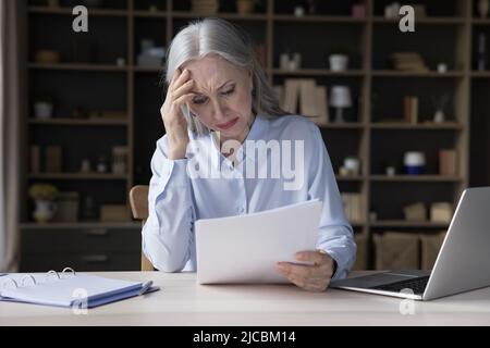 Verärgert reifen Geschäftsfrau immer schlechte Nachrichten in Papierbrief Stockfoto