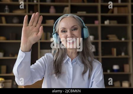Kopfaufnahme Porträt Ältere Frau in Kopfhörern tätigen Videoanruf Stockfoto
