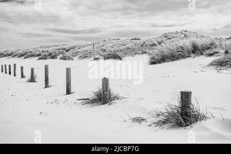 Holzpfosten am Strand von Ainsdale markieren den Umfang des von der Öffentlichkeit genutzten Parkplatzes. Stockfoto