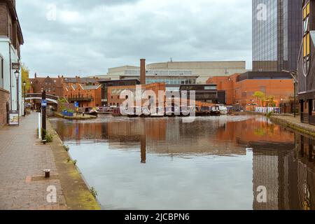 Hausboote Reihen sich auf dem Kanal am Regency Wharf an, umgeben von der Gegenüberstellung alter und neuer Architekturstile. Stockfoto