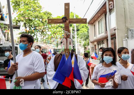 Manila, Philippinen. 12.. Juni 2022. Mitglieder einer religiösen Gemeinde tragen philippinische Flaggen, während sie eine Pilgerfahrt zum 124.. Jahrestag der Unabhängigkeit der Philippinen in Quezon City, Metro Manila, Philippinen, abhalten. 12. Juni 2022. Die Wallfahrt wurde vom philippinischen katholischen Priester P. Robert Reyes markiert die Dauer des Christentums im Land. (Bild: © Basilio Sepe/ZUMA Press Wire) Stockfoto